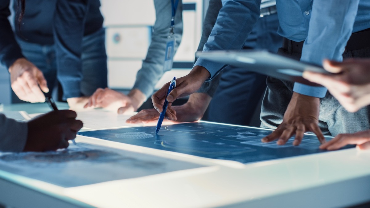 a manufacturing team reviewing VA/VE principles during a meeting